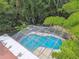 Aerial view of backyard, screened pool, lush landscaping, and vegetable plots, creating an urban farm oasis at 1402 E Mimosa Dr, Plant City, FL 33563