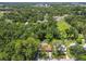 Aerial shot of a home with a screened-in pool surrounded by lush, mature greenery at 1402 E Mimosa Dr, Plant City, FL 33563