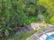 Aerial backyard view showcasing vegetable beds, mature plants, and a greenhouse at 1402 E Mimosa Dr, Plant City, FL 33563