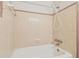 Beige tiled bathroom with a white bathtub and shower head at 1402 E Mimosa Dr, Plant City, FL 33563