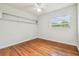 Bright bedroom featuring hardwood floors, fan, and shelving at 1402 E Mimosa Dr, Plant City, FL 33563