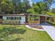 Beautiful front yard featuring a mid-century home with a landscaped garden and stylish architectural details at 1402 E Mimosa Dr, Plant City, FL 33563
