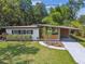 Charming mid-century home showcasing modern design, manicured lawn, and inviting curb appeal at 1402 E Mimosa Dr, Plant City, FL 33563