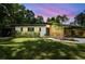 Charming single story home at sunset featuring a well maintained lawn and covered carport at 1402 E Mimosa Dr, Plant City, FL 33563