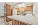 Bright kitchen features wood cabinetry, white appliances and an island with a speckled countertop at 1402 E Mimosa Dr, Plant City, FL 33563