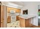 Light kitchen features an island, wood cabinets, white appliances, and tiled floor at 1402 E Mimosa Dr, Plant City, FL 33563