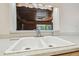 Kitchen sink with speckled countertop, paneled walls with a view of the outside at 1402 E Mimosa Dr, Plant City, FL 33563