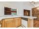 Kitchen with stainless steel sink, view of paneled room, wooden cabinets, white appliances and speckled countertop at 1402 E Mimosa Dr, Plant City, FL 33563