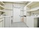 View of laundry room showing white washer, dryer, and shelving with wooden trim at 1402 E Mimosa Dr, Plant City, FL 33563