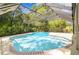 Large in-ground screened pool surrounded by mature landscaping at 1402 E Mimosa Dr, Plant City, FL 33563