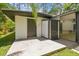 View of the exterior of the backyard shed with black doors and concrete patio at 1402 E Mimosa Dr, Plant City, FL 33563