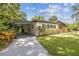 View of a single story home featuring a well maintained lawn and a long driveway at 1402 E Mimosa Dr, Plant City, FL 33563
