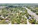 Expansive aerial view showcasing a wooded lot in a residential neighborhood with mature trees and proximity to a main road at 14619 Daybreak Dr, Lutz, FL 33559