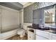 Bathroom featuring shower over tub, mosaic tile backsplash, and large mirror at 14619 Daybreak Dr, Lutz, FL 33559