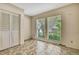 Bedroom with tile flooring, closet, and two windows overlooking the lush backyard at 14619 Daybreak Dr, Lutz, FL 33559