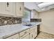 Cozy kitchen featuring ample cabinet space, tile backsplash, and double basin sink at 14619 Daybreak Dr, Lutz, FL 33559