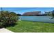 Backyard featuring vibrant green grass, a privacy fence, and mature landscaping at 1583 Eunice Ln, Clearwater, FL 33756