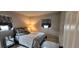 Inviting bedroom with patterned bedding, gray walls, a side table lamp, and two window views at 1583 Eunice Ln, Clearwater, FL 33756