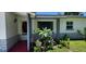 Inviting front porch with decorative plants, tiled floor and a view of the front lawn at 1583 Eunice Ln, Clearwater, FL 33756