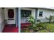 Inviting front porch with decorative plants, tiled floor and a view of the front lawn at 1583 Eunice Ln, Clearwater, FL 33756
