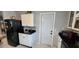Kitchen features white cabinets, black countertops and appliances, and a door to the outside at 1583 Eunice Ln, Clearwater, FL 33756