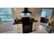 Modern kitchen featuring white cabinets, black countertops and appliances, and tile backsplash at 1583 Eunice Ln, Clearwater, FL 33756