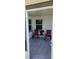 Enclosed patio featuring tile flooring, two red chairs, and a small table with a potted plant at 1583 Eunice Ln, Clearwater, FL 33756