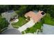 An aerial view showcases the property's tile roof, long driveway, manicured lawn, and verdant landscaping at 1827 Foxboro Ct, Oldsmar, FL 34677