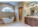 Elegant bathroom featuring a soaking tub under a large window and modern fixtures at 1827 Foxboro Ct, Oldsmar, FL 34677