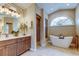 Luxurious bathroom with a soaking tub, a large window, and a glass enclosed shower at 1827 Foxboro Ct, Oldsmar, FL 34677