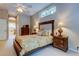Comfortable bedroom featuring a decorative headboard, neutral walls, and ample natural light at 1827 Foxboro Ct, Oldsmar, FL 34677