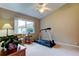 Comfortable bedroom features a ceiling fan, window, and fitness equipment at 1827 Foxboro Ct, Oldsmar, FL 34677