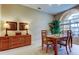 Dining room with a wooden table and chairs, complemented by a sideboard and a bright window at 1827 Foxboro Ct, Oldsmar, FL 34677