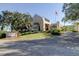 Inviting entrance with lush landscaping, mature trees, and American flag at 1827 Foxboro Ct, Oldsmar, FL 34677