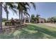 Beautifully landscaped lawn and clubhouse exterior with tropical plants and manicured shrubbery at 1827 Foxboro Ct, Oldsmar, FL 34677