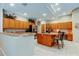 Large kitchen features ample counter space, central island with cooktop and stainless refrigerator at 1827 Foxboro Ct, Oldsmar, FL 34677