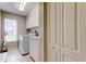 Functional laundry room featuring white cabinets, washer and dryer, and a window for natural light at 1827 Foxboro Ct, Oldsmar, FL 34677