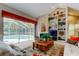 Bright living room boasts a fireplace, built-in shelving, and seamless access to a screened-in patio with a pool at 1827 Foxboro Ct, Oldsmar, FL 34677