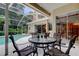 The screened-in patio features comfortable seating and views of the pool and lush landscaping at 1827 Foxboro Ct, Oldsmar, FL 34677