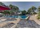 Beautiful lap pool with lounge chairs and shade umbrellas on a sunny day at 1827 Foxboro Ct, Oldsmar, FL 34677
