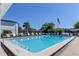 Community pool featuring clear blue water, a ladder, and poolside lounge chairs at 1827 Foxboro Ct, Oldsmar, FL 34677