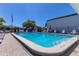 Community pool featuring clear blue water, a ladder, and poolside lounge chairs at 1827 Foxboro Ct, Oldsmar, FL 34677