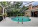 Relax in the screened-in pool and spa with tropical landscaping offering privacy at 1827 Foxboro Ct, Oldsmar, FL 34677