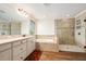 Bright bathroom showcasing a soaking tub, shower with glass door, and a dual sink vanity with great countertop space at 19209 Long Lake Ranch Blvd, Lutz, FL 33558