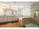 Bright bathroom showcasing a soaking tub, shower with glass door, and a dual sink vanity with great countertop space at 19209 Long Lake Ranch Blvd, Lutz, FL 33558