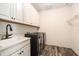 Laundry room featuring a sink, cabinets, and modern washer and dryer at 19209 Long Lake Ranch Blvd, Lutz, FL 33558