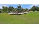 Community playground with multiple slides and play structures in a well-maintained grassy area at 19209 Long Lake Ranch Blvd, Lutz, FL 33558