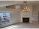 Cozy living room featuring fireplace, bright windows, chandelier, and view to adjacent rooms at 1922 Blue Sage Ct, Brandon, FL 33511