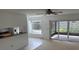 Bright living room featuring patio access, view to kitchen, and plush carpets at 1922 Blue Sage Ct, Brandon, FL 33511