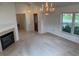 Bright living room featuring fireplace, hardwood floors, chandelier, and view to adjacent rooms at 1922 Blue Sage Ct, Brandon, FL 33511
